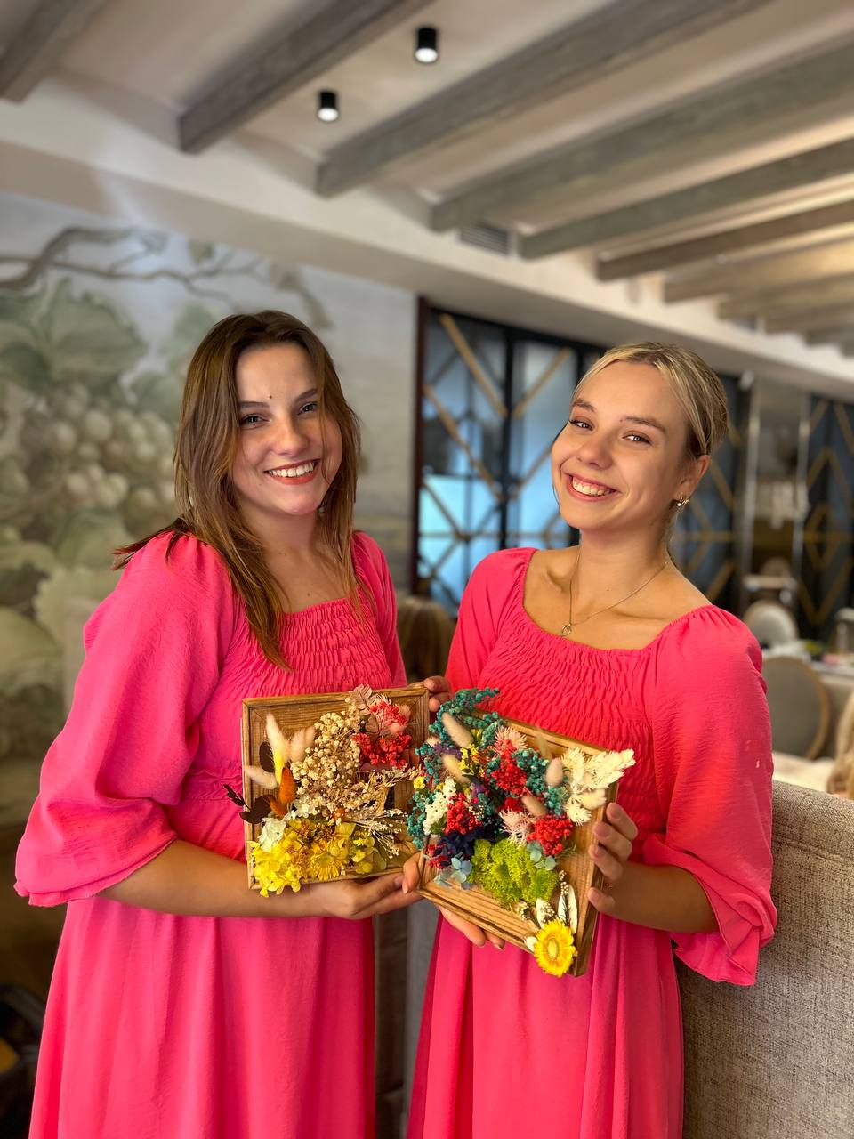 Процес створення картини з сухоцвітами: розміщення квітів і трав у рамці під керівництвом майстрині.