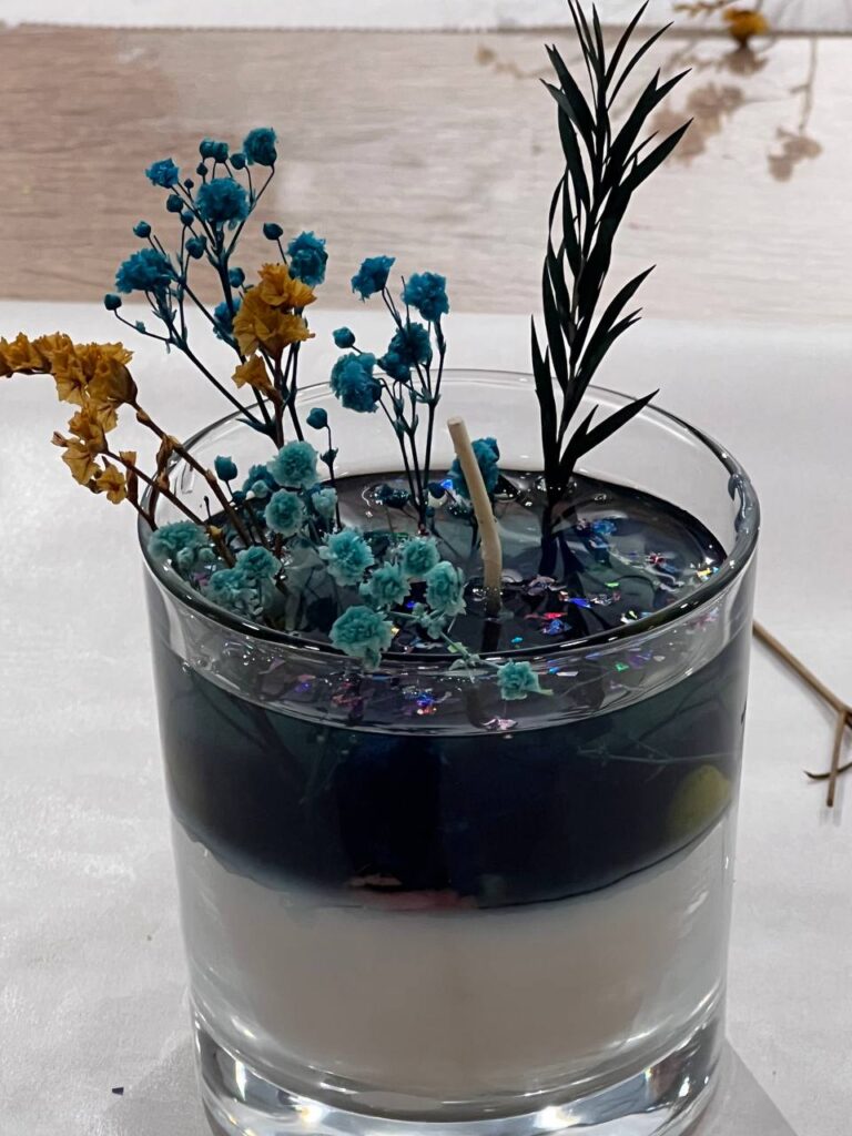 Ароматна свічка ручної роботи з гілочкою ялівцю та декором у святковому стилі.