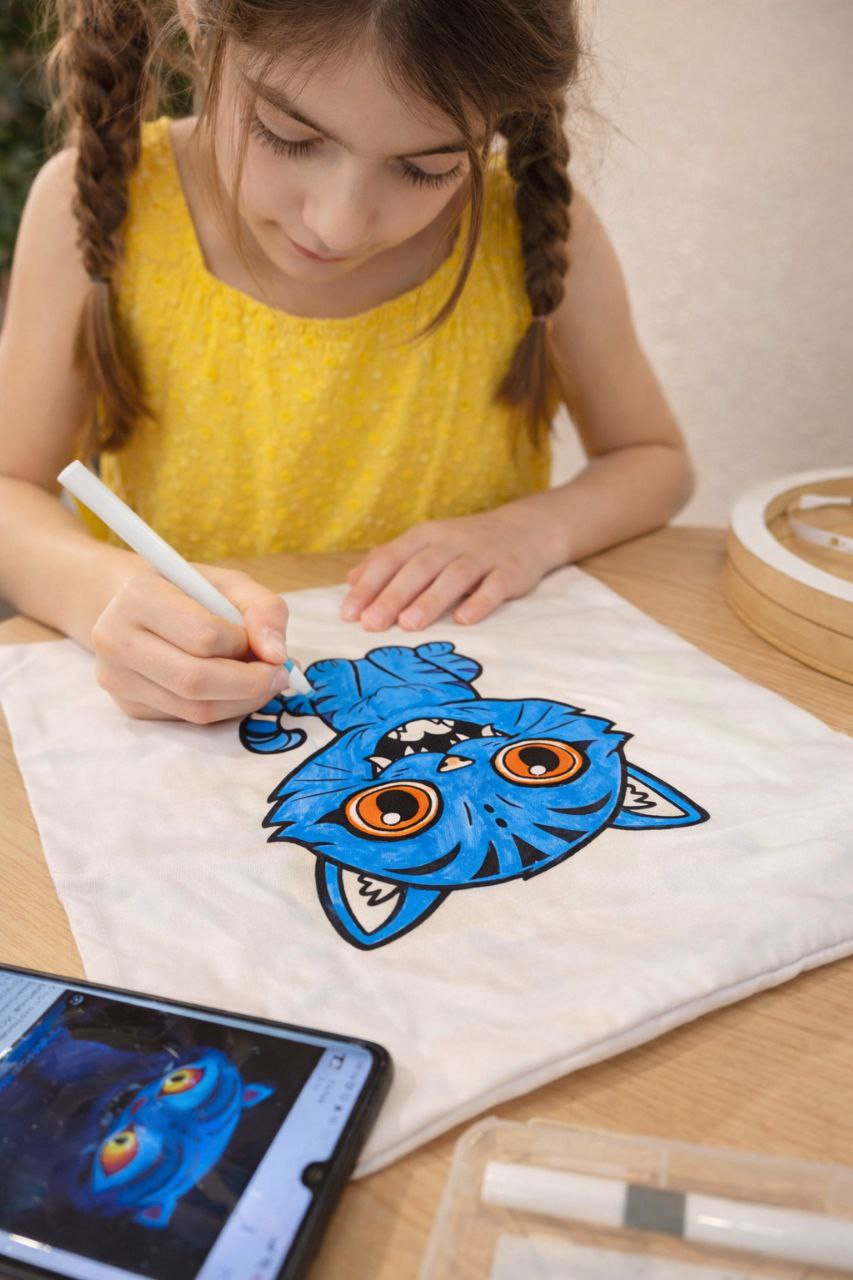 Дитина розмальовує подушку фарбами та акриловими маркерами — творчий майстер-клас для дітей